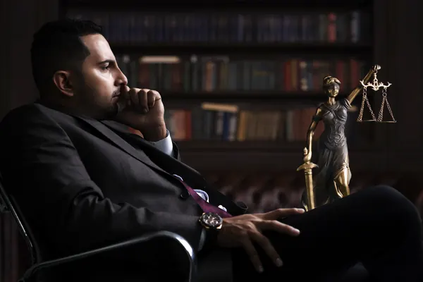 Cristian Portilla in library with Lady Justice statue